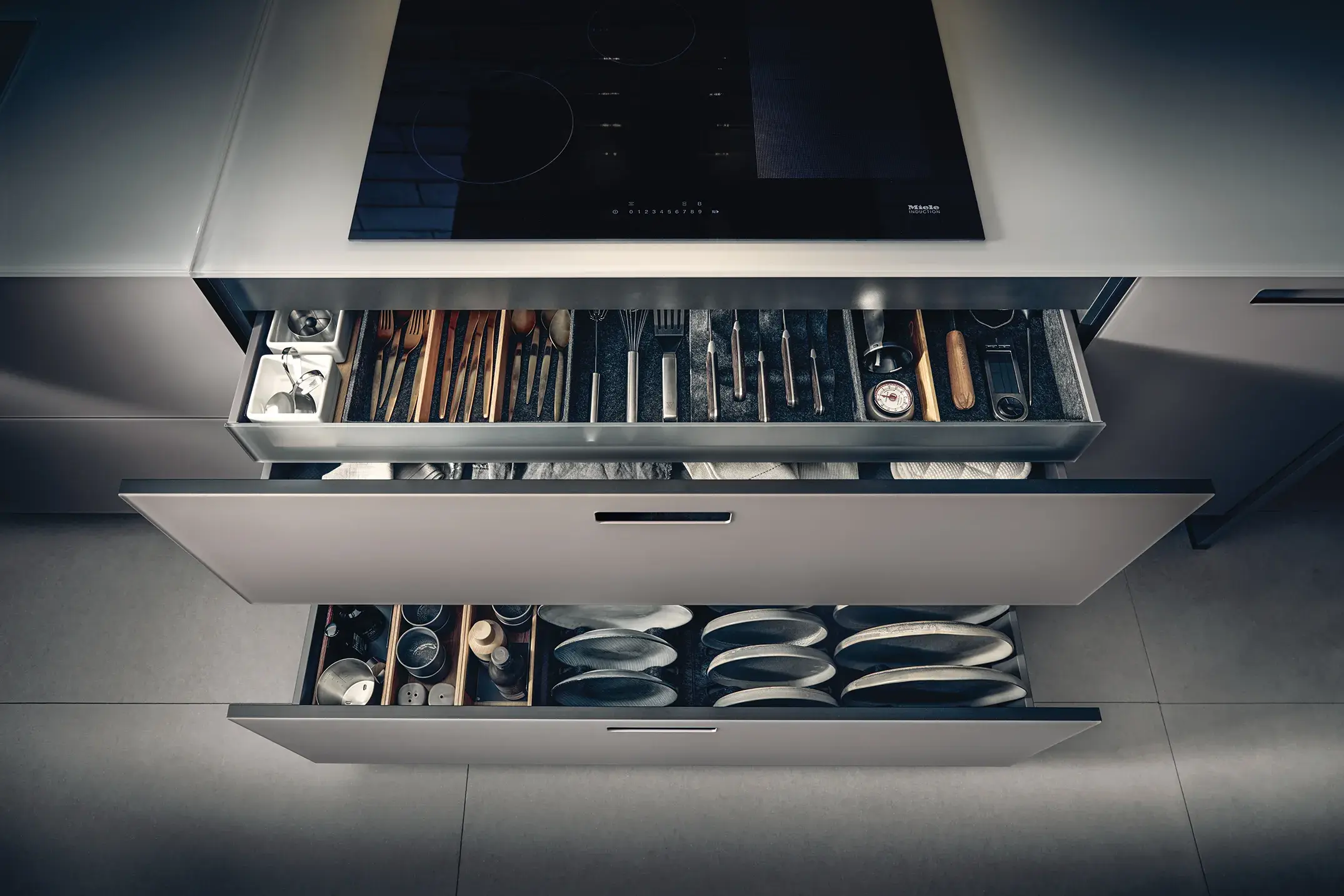 systemo Glasarbeitsplatte und -küchenfronten und Glaszargen geöffnete Auszüge unter Kochfeld